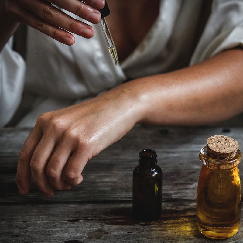 A person is using Essential Oil Wizardry products